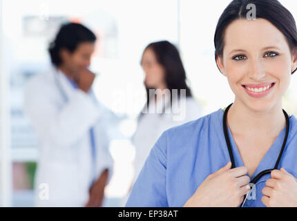 Zuversichtlich Krankenschwester stehend zusammen mit ihrem Team im Hintergrund Stockfoto