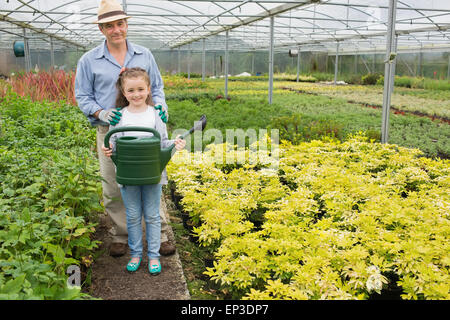 Gärtner mit Enkelin hält Bewässerung können Stockfoto