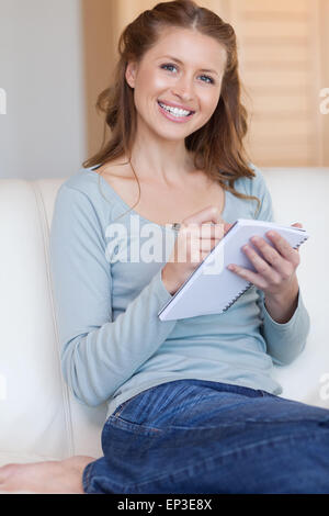 Frau, die Notizen auf der couch Stockfoto