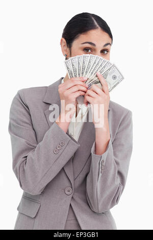 Junge Verkäuferin versteckt ihr Gesicht hinter Banknoten Stockfoto