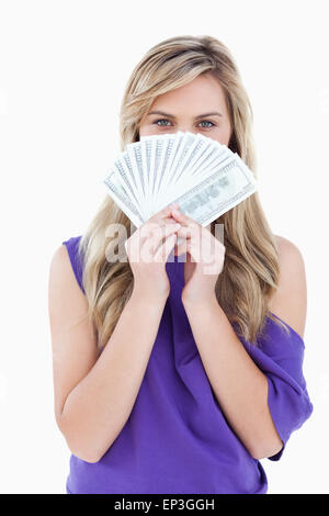 Blonde Frau verbirgt ihr Gesicht hinter ein Fan von Notizen Stockfoto