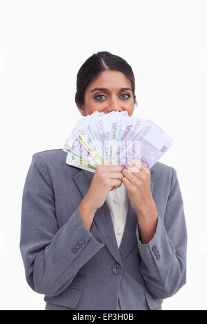 Unternehmerin, versteckt ihr Gesicht hinter Banknoten Stockfoto