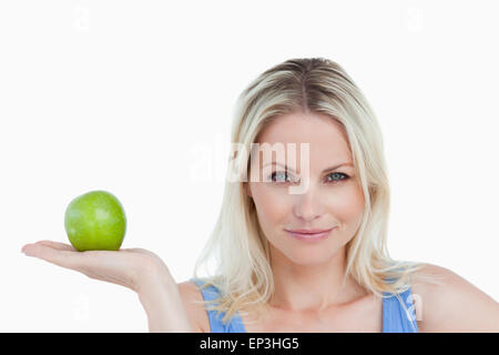 Blonde Frau hält einen Apfel in ihre Hand mit der Handfläche Stockfoto