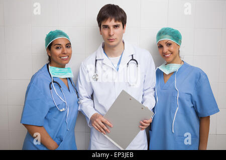 Arzt mit Zwischenablage steht zwischen zwei Krankenschwestern Stockfoto