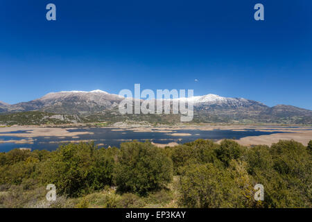 Stymfalia See im Corinthia Präfektur, Griechenland mit den schneebedeckten Bergen als Hintergrund reflektiert in den Gewässern des Sees Stockfoto