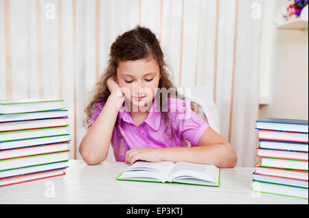 Kleine Brünette lächelndes Mädchen mit Stapel Bücher Stockfoto