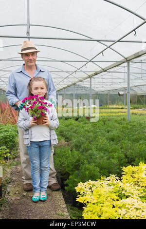 Kleines Mädchen hält Blume Topf stehen mit ihrem Opa Stockfoto