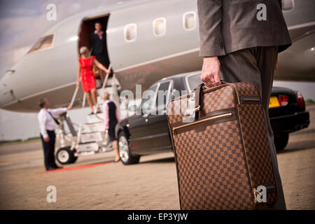 Koffer, einem privaten Flugzeug durchgeführt werden, wie Passagiere Flug landet Stockfoto