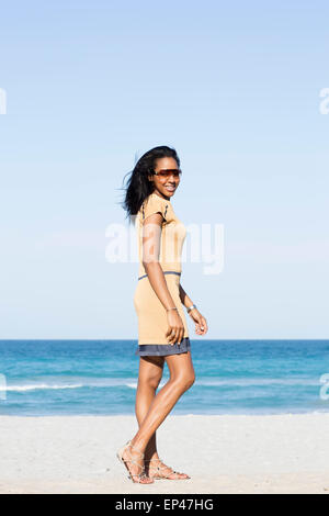 Junge, stilvolle Frau, die am Strand spaziert Stockfoto