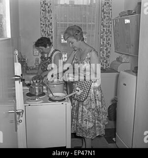 Deutsche Fernsehansagerin Angelika Feldmann hilft ihrer Mutter in der Küche beim Kochen, Deutschland 1950er Jahre. Deutsche TV Stockfoto