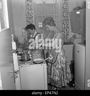 Deutsche Fernsehansagerin Angelika Feldmann hilft ihrer Mutter in der Küche beim Kochen, Deutschland 1950er Jahre. Deutsche TV Stockfoto
