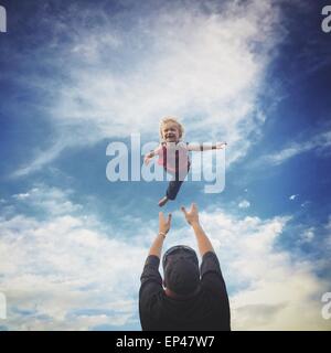 Vater seinen Sohn in die Luft werfen Stockfoto