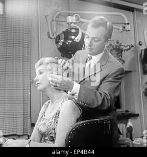 Deutsche Fernsehansagerin Angelika Feldmann beim Frisurencheck bei Friseur Haak, Deutschland 1950er Jahre. Deutsche TV vorhanden Stockfoto