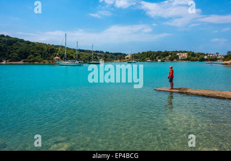 Porto Cheli Portocheli Hafen Hafen, Griechenland, mit Booten und einsame Figur, blauer Himmel, blaues Meer Stockfoto