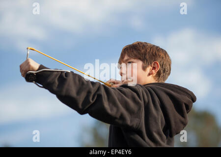 Ein Junge mit dem Ziel einer Schleuder im Freien. Stockfoto