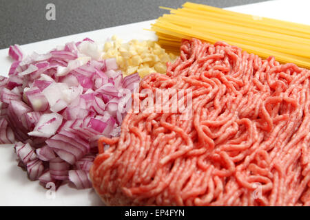 Hackfleisch / Faschiertes (Hackfleisch) mit Spaghetti, Zwiebeln und Knoblauch auf Schneidebrett Stockfoto