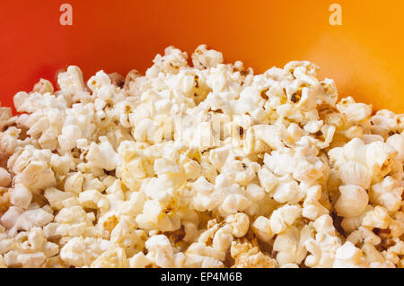 Popcorn in orange leuchtend Plastikschüssel Stockfoto