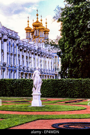 12. Juni 1998 - Puschkin, Russland - über die formale Gärten mit der klassischen Skulptur betrachtet sind die goldene Zwiebel Kuppel Kuppeln der russischen orthodoxen Kirche der Auferstehung erhebt sich über Katharinenpalast, eine Sommerresidenz der russischen Zaren, benannt nach Katharina i., Ehefrau von Peter dem großen. Ein Rokoko-Schloss mit einer barocken Fassade aufwändig verziert in blau und weiß, mit vergoldeten Atlantes, Karyatiden und Pilaster, es ist in der Stadt Puschkin (Tsarskoye Selo) 25 km (15,5 km) südöstlich von St. Petersburg (Leningrad) und ist einer der beliebtesten Besucher und Touristen Attraktionen. Stockfoto