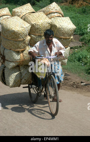 TAMIL NADU, Indien, circa 2009: ein nicht identifizierter Mann und seinem überladenen Fahrrad fahren in die Stadt, ca. 2009 in Tamil Nadu, Indien. Stockfoto