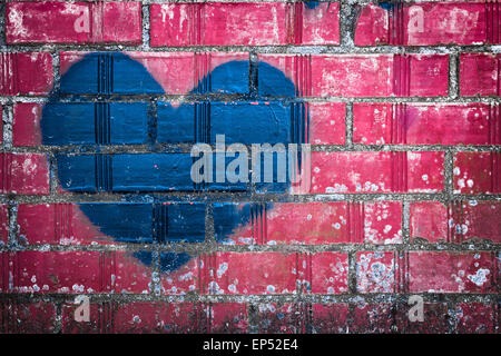 Ein blaues Herz, gemalt mit Spray kann auf eine rosa Wand. Stockfoto