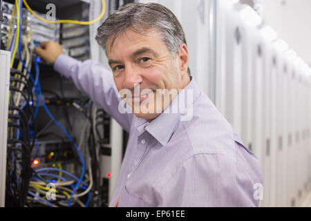 Techniker, die Kabel in die Server-Gehäuse ändern Stockfoto
