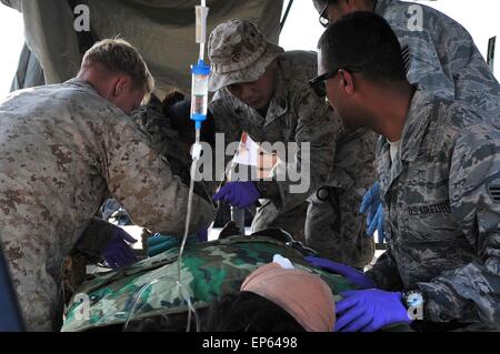 Kathmandu, Nepal. 13. Mai 2015. Ein US-Flieger und Segler bieten medizinische Notfallbehandlung für einen nepalesischen Mann im Triage-Setup an der Tribhuvan International Airport 12. Mai 2015 in Kathmandu, Nepal. Ein 7,3 Größenordnung Nachbeben Erdbeben das Königreich nach dem Erdbeben der Stärke 7,8 am 25. April. Stockfoto