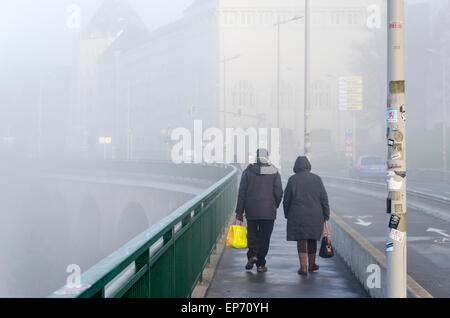 Altes Ehepaar zu Fuß in Richtung Stadtzentrum von Luxemburg-Stadt, an der Brücke über die Petruss in den nebligen Morgen Stockfoto