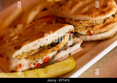 Gegrillte Hähnchen und Portobello Pilze Panini mit knusprigen Zwiebelringen und einer Seitenlänge von goldene Pommes frites Stockfoto