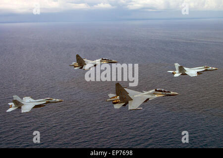 Zwei US-Navy F/A - 18C Hornet-Kampfflugzeuge fliegen in Formation mit zwei russischen gemacht Royal Malaysian Air Force SU-30MKM Flanker H Kämpfer während eine gemeinsame Übung mit dem Flugzeugträger USS Carl Vinson 10. Mai 2015 in das Südchinesische Meer. Stockfoto