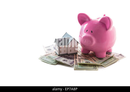 Sparschwein und Miniatur Haus ruht auf Haufen von Dollar Stockfoto