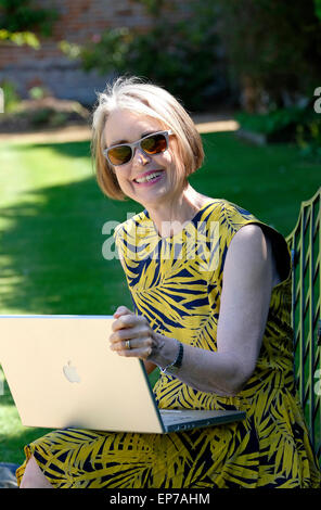 ältere Frau mit Laptop-Computer im Garten Stockfoto