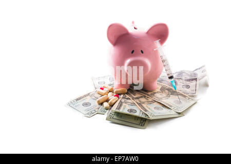 Sparschwein-Tabletten und Spritze ruht auf Haufen von Dollar Stockfoto