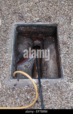 Abwasser Abfluss mit Stangen gelöscht wird Stockfoto