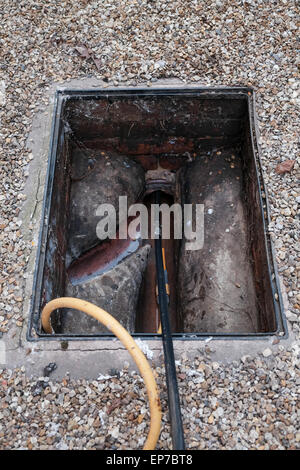 Abwasser Abfluss mit Stangen gelöscht wird Stockfoto
