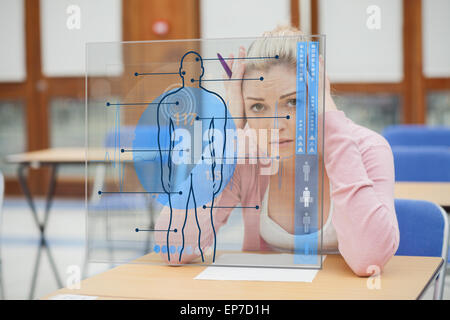 Blonde Frau denken schwer während des Studiums auf Schnittstelle mit Körper Stockfoto