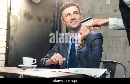 Gut aussehender Mann mit Bankkarte Kellner im café Stockfoto