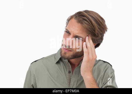 Mann mit Kopfschmerzen wegsehen und seinen Kopf berühren Stockfoto