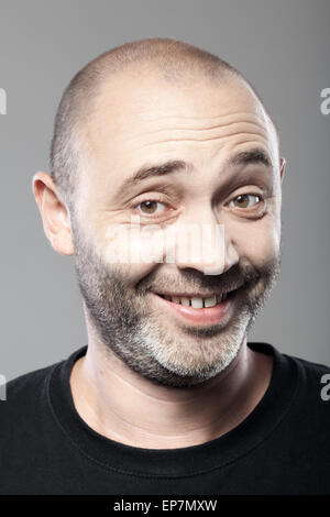 Porträt des ironisch lächelnde Menschen isoliert auf grau Stockfoto
