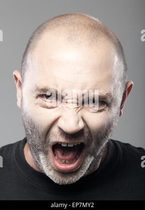 Porträt der böse Mann Sreaming isoliert auf grau Stockfoto