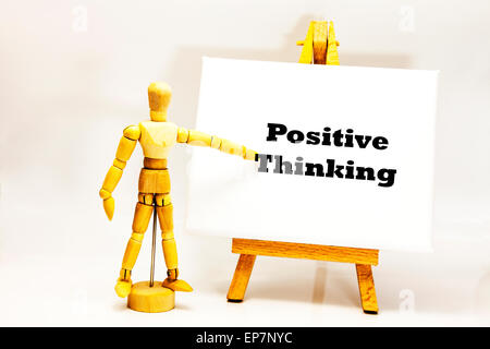 Hölzerne Mann mit weißen Tafel zeigt auf Worte "Positives Denken" mit Verstand zu Kontrolle Muster Affirmationen Einstellung outlook Stockfoto