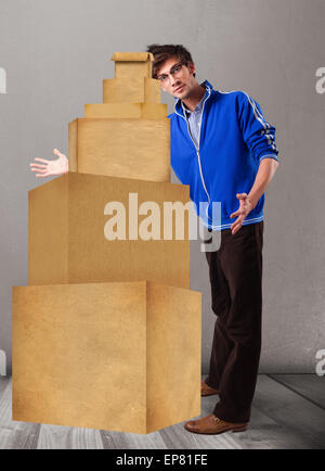 Junger Mann hält eine Reihe von braunen Kartons Stockfoto