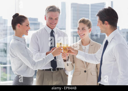Gruppe von Geschäftsleuten, die ihre Flöten Champagner Klirren Stockfoto