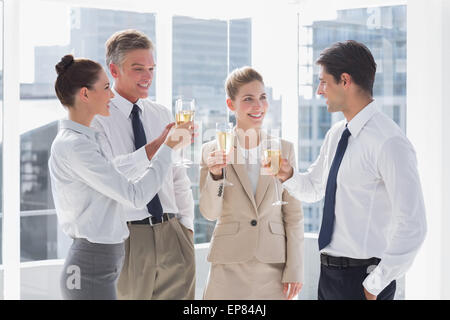 Lächelnd Team von Geschäftsleuten, die ihre Flöten Champagner Klirren Stockfoto