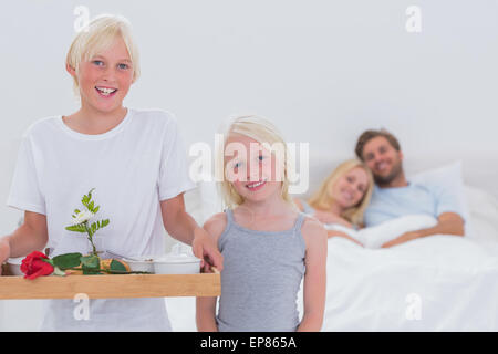 Kinder bringen ihre Eltern das Frühstück im Bett Stockfoto