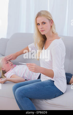 Besorgte Mutter ihre Töchter Temperatur prüfen Stockfoto