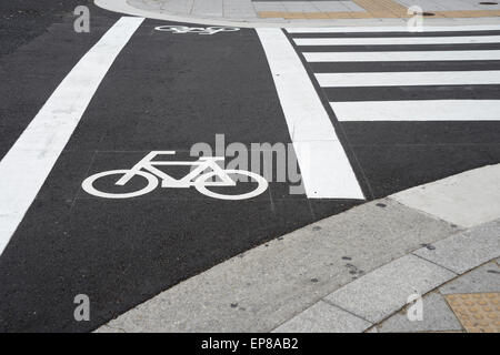 Fahrrad-Zeichen neben Zebrastreifen in Stadt für Radweg auf der Straße. Stockfoto
