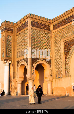 Einheimische Frauen zu Fuß durch die schönen Bab Mansour in der alten Stadtmauer von Meknes. Stockfoto