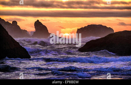 Hohe Brandung stürzt in den Meer-Stack-Felsen bei Sonnenuntergang am Bandon Strand an der Küste Oregons. Stockfoto