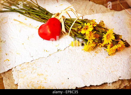 Bouquet von Löwenzahn auf Büttenpapier mit kleinen roten Herzen. Liebesbrief. Sommer Hintergrund. Vintage Karte Stockfoto