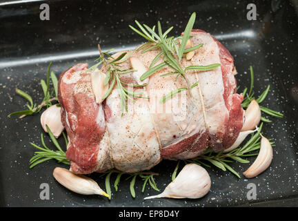 Lammschulter Braten mit Knoblauch und frischem Rosmarin. Ein frisch gebratenes bestreut mit schwarzem Pfeffer in der Pfanne braten Stockfoto